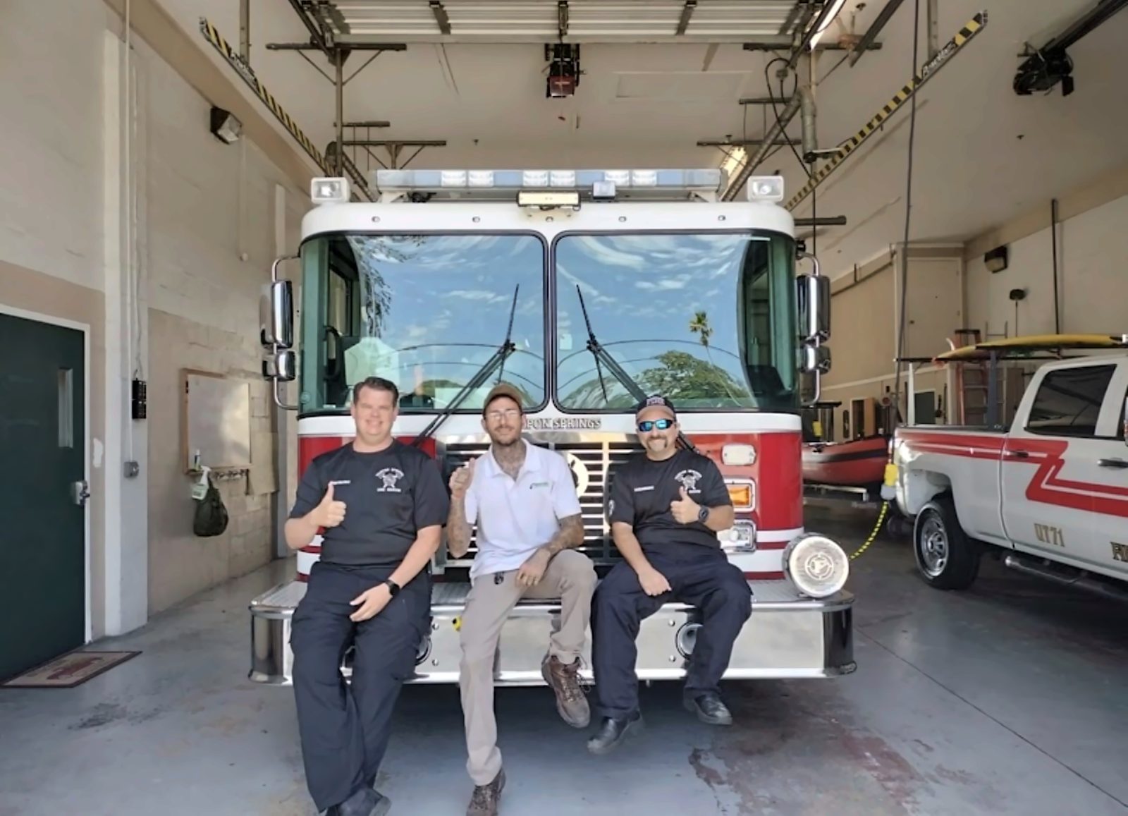 Express Air Duct Cleaning team members giving a thumbs up in front of a fire engine